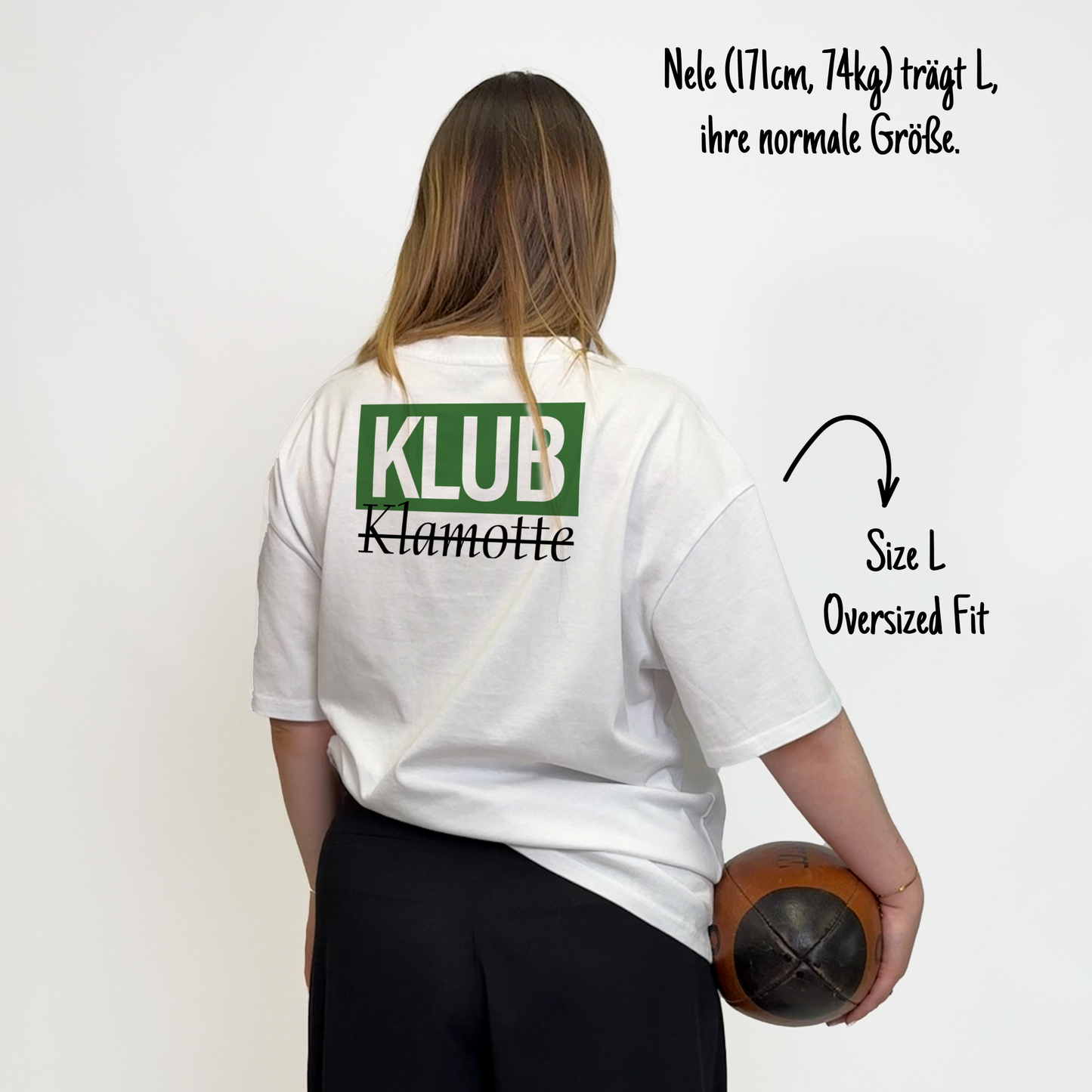Nele (171cm, 74kg) trägt das weiße Klub Font Tee in L. Man sieht das Model von hinten. Das Shirt ist oversized geschnitten und hat einen großen Print auf dem Rücken: Ein großes grünes Rechteck mit dem weißen Schriftzug "KLUB" und darunter in schwarzer Schrift und durchgestrichen Klamotte.