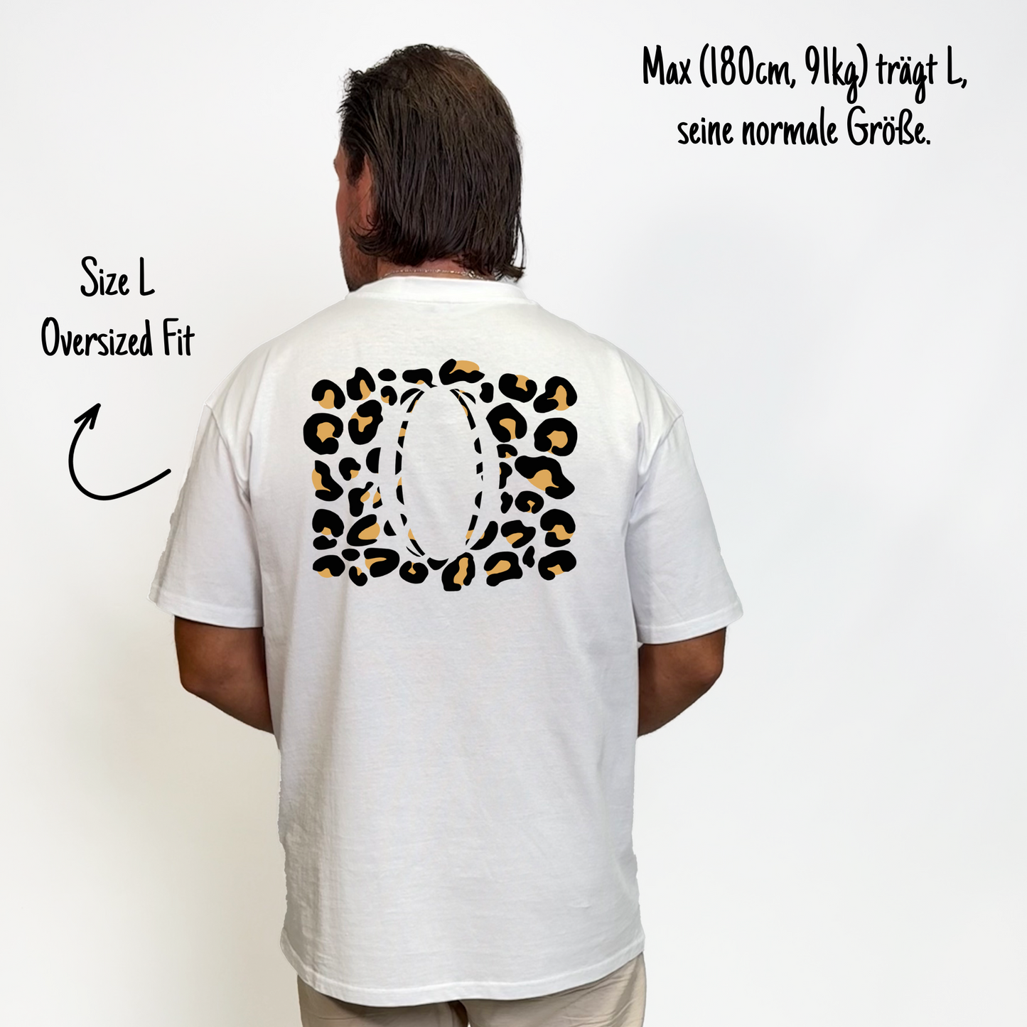 Max (180cm, 91kg) trägt das weiße Klub Leo Tee in L. Man sieht das Model von hinten. Das Shirt ist oversized geschnitten und hat einen großen weißen Print auf dem Rücken: sandfarbene Leoparden-Flecken rechteckig über den ganzen Rücken, in der Mitte ein großer Rugbyball ausgespart.