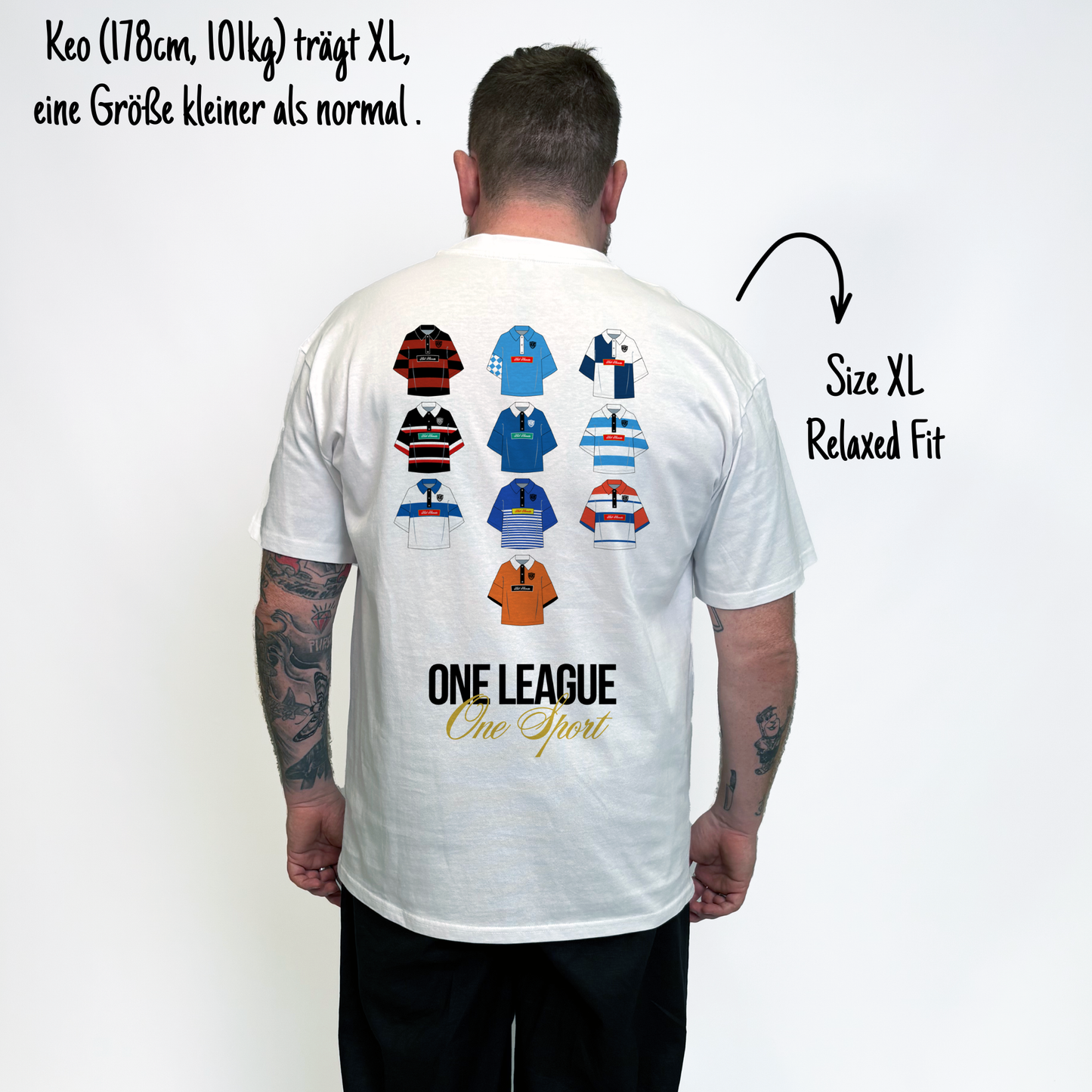 Keo (178cm, 101kg) trägt das weiße One League Tee in XL. Man sieht das Model von vorne. Er trägt das Shirt im Relaxed Fit, eine Größe kleiner als normal. Das Shirt hat einen großen Print auf dem Rücken: Zehn Rugby Trikots aus der 1.Bundesliga Rugby Deutschland und darunter in schwarzer Schrift und in Großbuchstaben ONE LEAGUE, sowie darunter in goldener kalligraphischer Schrift One Sport.