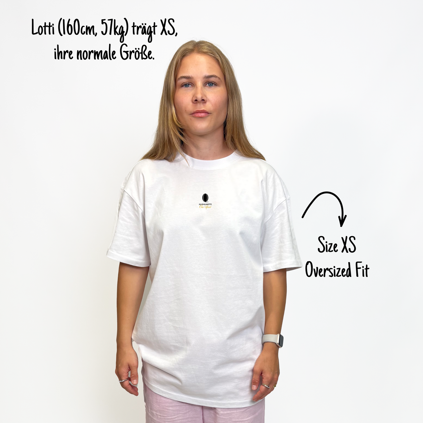Lotti (160cm, 57kg) trägt das weiße Klub Leo Tee in XS. Man sieht das Model von vorne. Das Shirt ist oversized geschnitten und hat einen kleinen schwarzen Print auf der Brust: das Klub Klamotte Logo. Darunter in goldener kalligraphischer Schrift One Sport.
