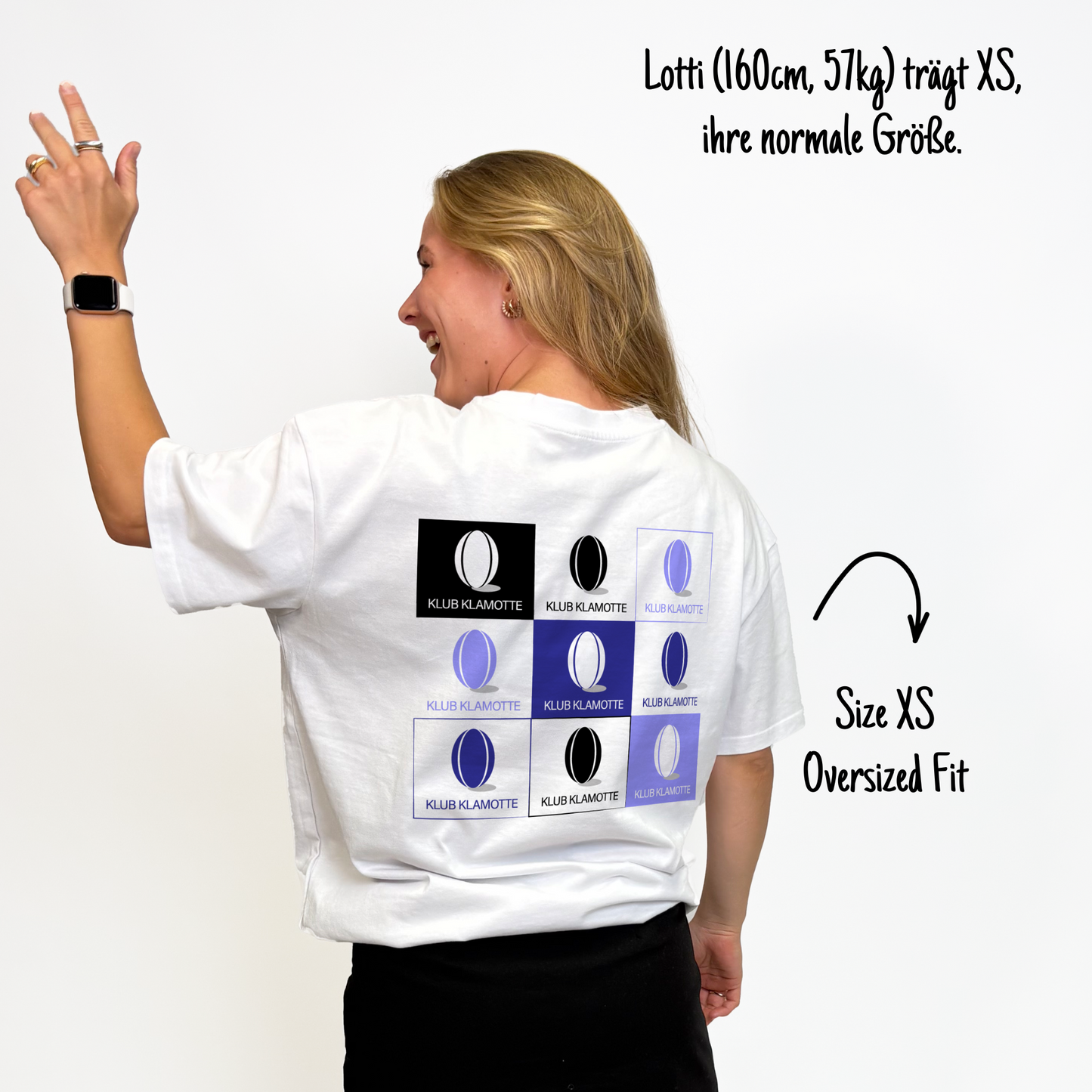Lotti (160cm, 57kg) trägt das weiße Klub Print Tee in XS. Man sieht das Model von hinten. Das Shirt ist oversized geschnitten und hat einen großen Print auf dem Rücken: eine Reihe von 3 mal 3 Quadraten, in jedem das Klub Klamotte Logo, welches einen Rugbyball und den Schriftzug Klub Klamotte darstellt. Die Quadrate haben alle eine unterschiedliche Farbe, entweder schwarz oder verschiedene Lila-Töne.