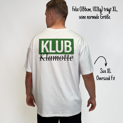 Felix (186cm, 102kg) trägt das weiße Klub Font Tee in XL. Man sieht das Model von hinten. Das Shirt ist oversized geschnitten und hat einen großen Print auf dem Rücken: Ein großes grünes Rechteck mit dem weißen Schriftzug "KLUB" und darunter in schwarzer Schrift und durchgestrichen Klamotte.