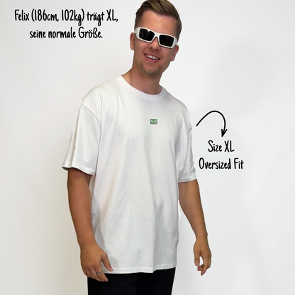 Felix (186cm, 102kg) trägt das weiße Klub Font Tee in XL. Man sieht das Model von vorne. Das Shirt ist oversized geschnitten und hat einen kleinen Print auf der Brust: das Wort KLUB in einem grünen Rechteck hinterlegt und darunter in Schwarz und durchgestrichen Klamotte.