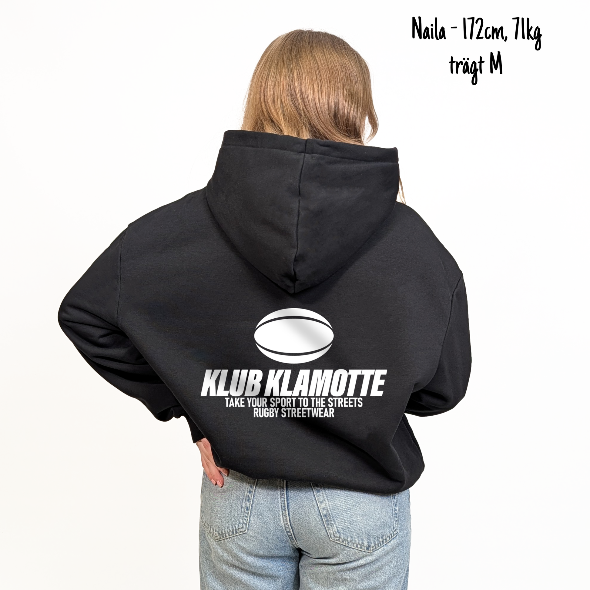 Naila (172cm, 71kg) trägt den schwarzen Klub Streets Hoodie in M. Man sieht das Model von hinten. Der Hoodie hat einen großen Print auf dem Rücken: ein quer liegender Rugby Ball, darunter der Schriftzug Klub Klamotte und darunter "Take your sport to the streets, Rugby Streetwear".