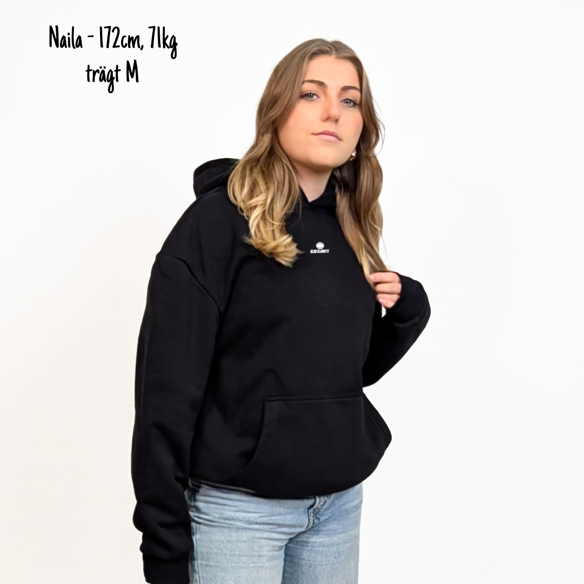Naila (172cm, 71kg) trägt den schwarzen Klub Streets Hoodie in M. Man sieht das Model von vorne. Der Hoodie hat einen kleinen Print auf der Brust: ein quer liegender Rugby Ball, darunter der Schriftzug Klub Klamotte.