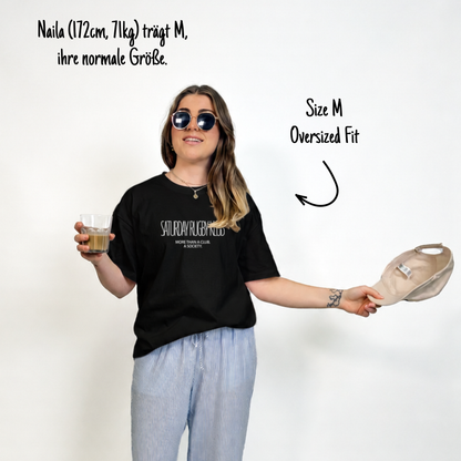 Naila (172cm, 71kg) trägt das schwarze Klub Tee in XL. Man sieht das Model von vorne. Das Shirt ist relaxed geschnitten und hat einen Print auf der Brust: Saturday Rugby Klub - More then a club a society.